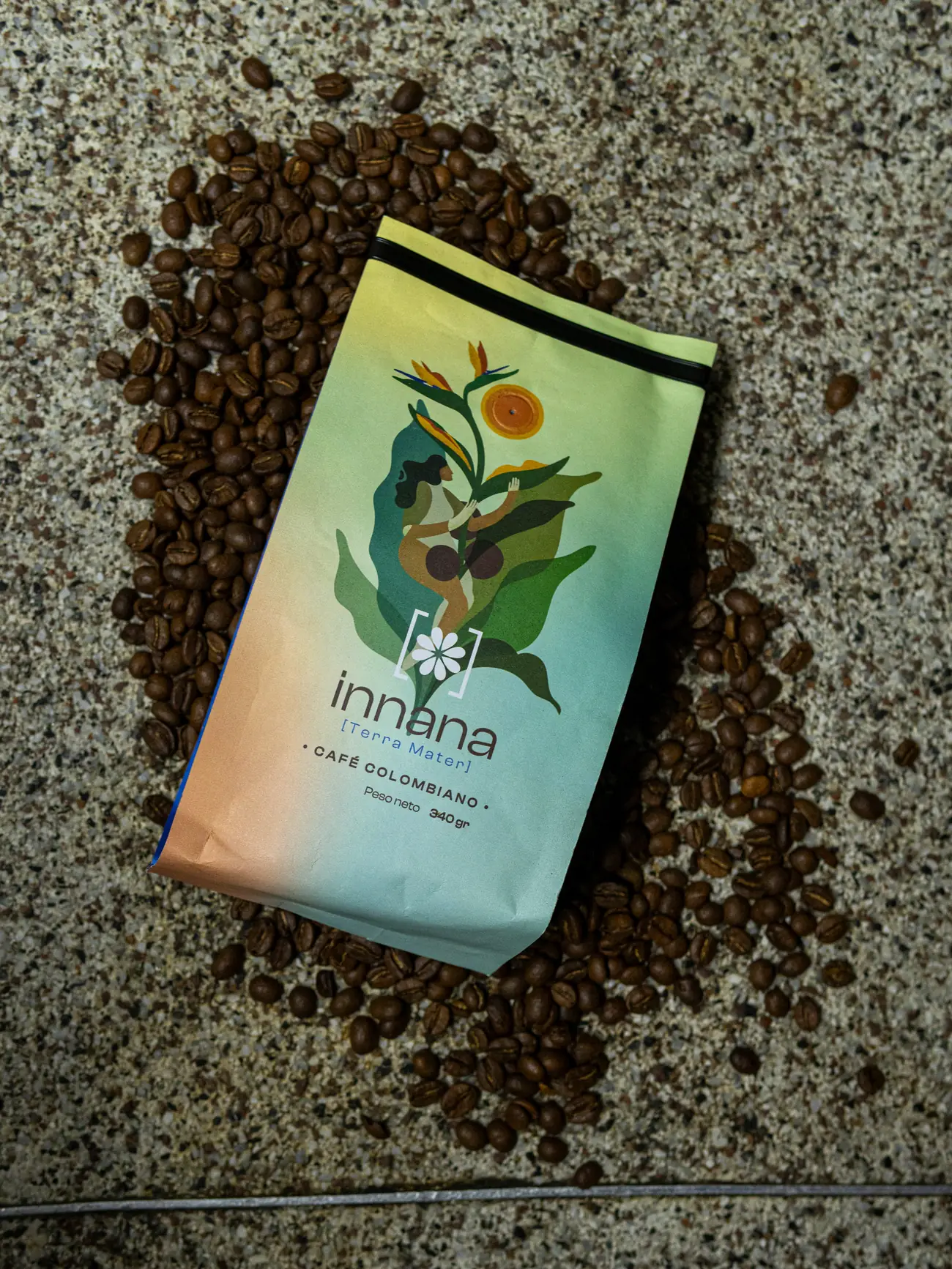 Bolsa de café Innana Terra Mater sobre granos de café tostado